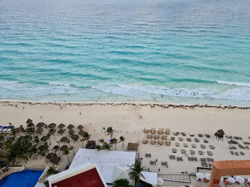 Cancun, Mexiko - Aerial view of a resort beach with people enjoying the summer by the seashore.