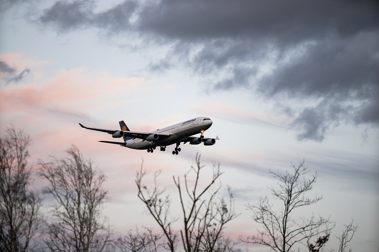 Ein Lufthansa-Flugzeug im Landeanflug bei Sonnenuntergang.
