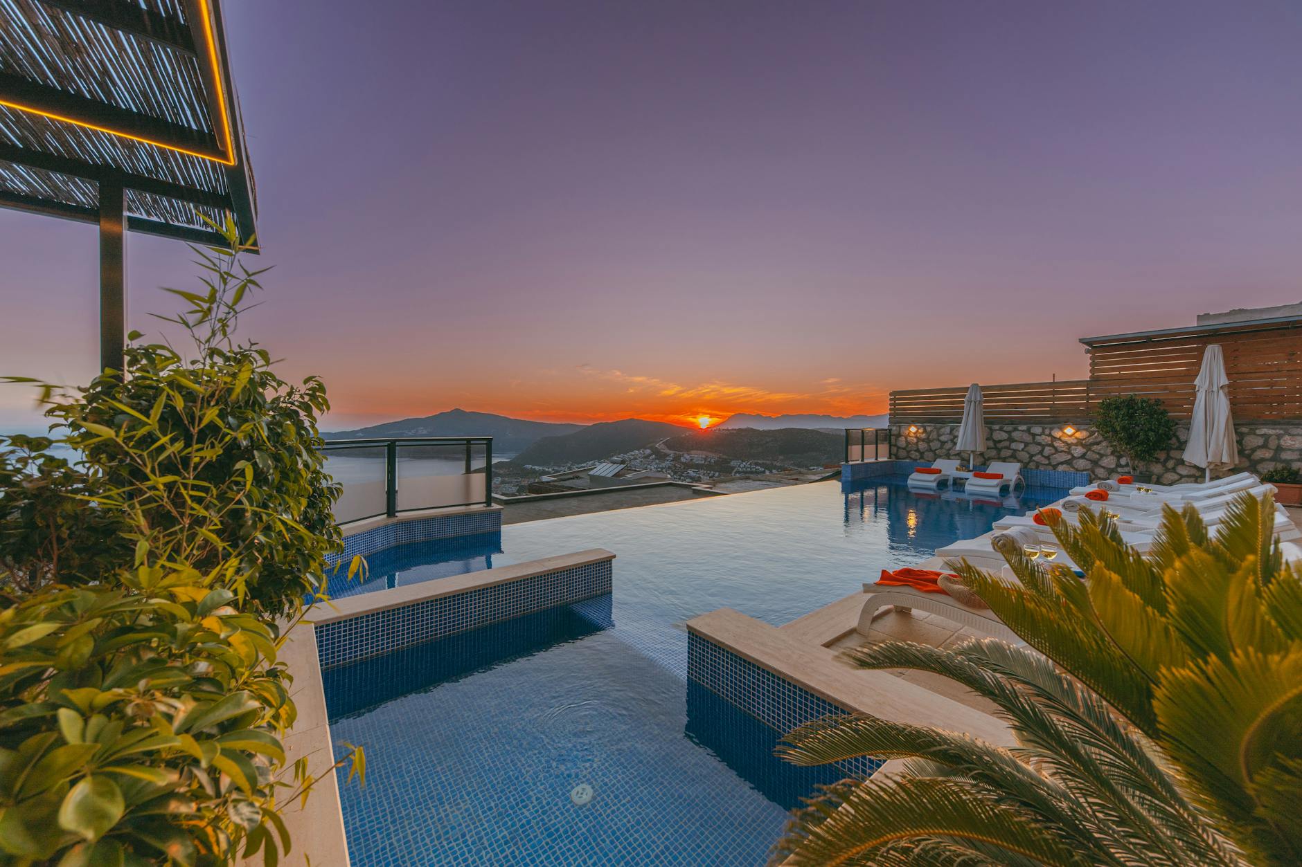 Honeymoon Romantik Sonnenuntergang - Infinity pool at a luxury resort with a stunning sunset view, lush plants, and c
