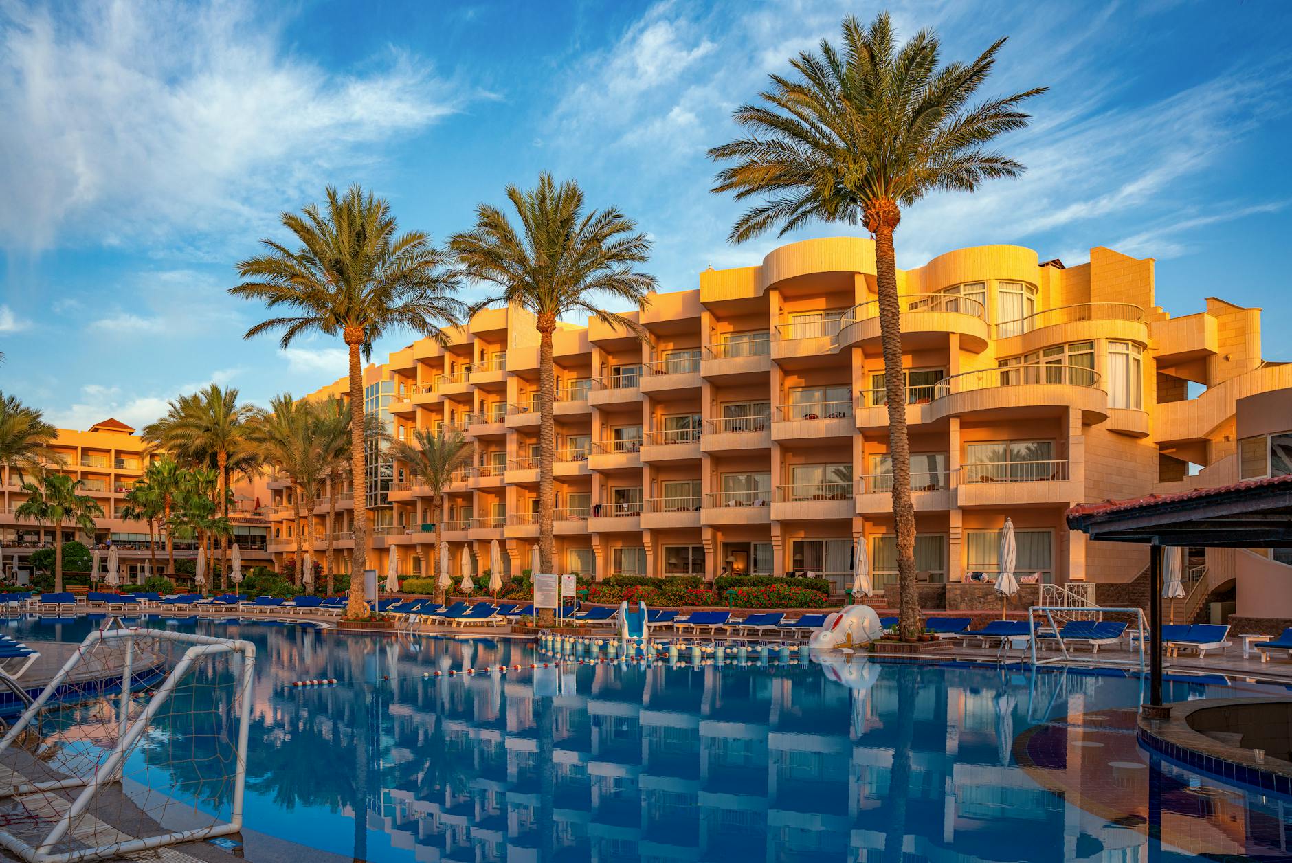 Hotel Resort Pool Luxus - Elegant hotel with palm trees and poolside in Hurghada, Egypt during a sunny day
