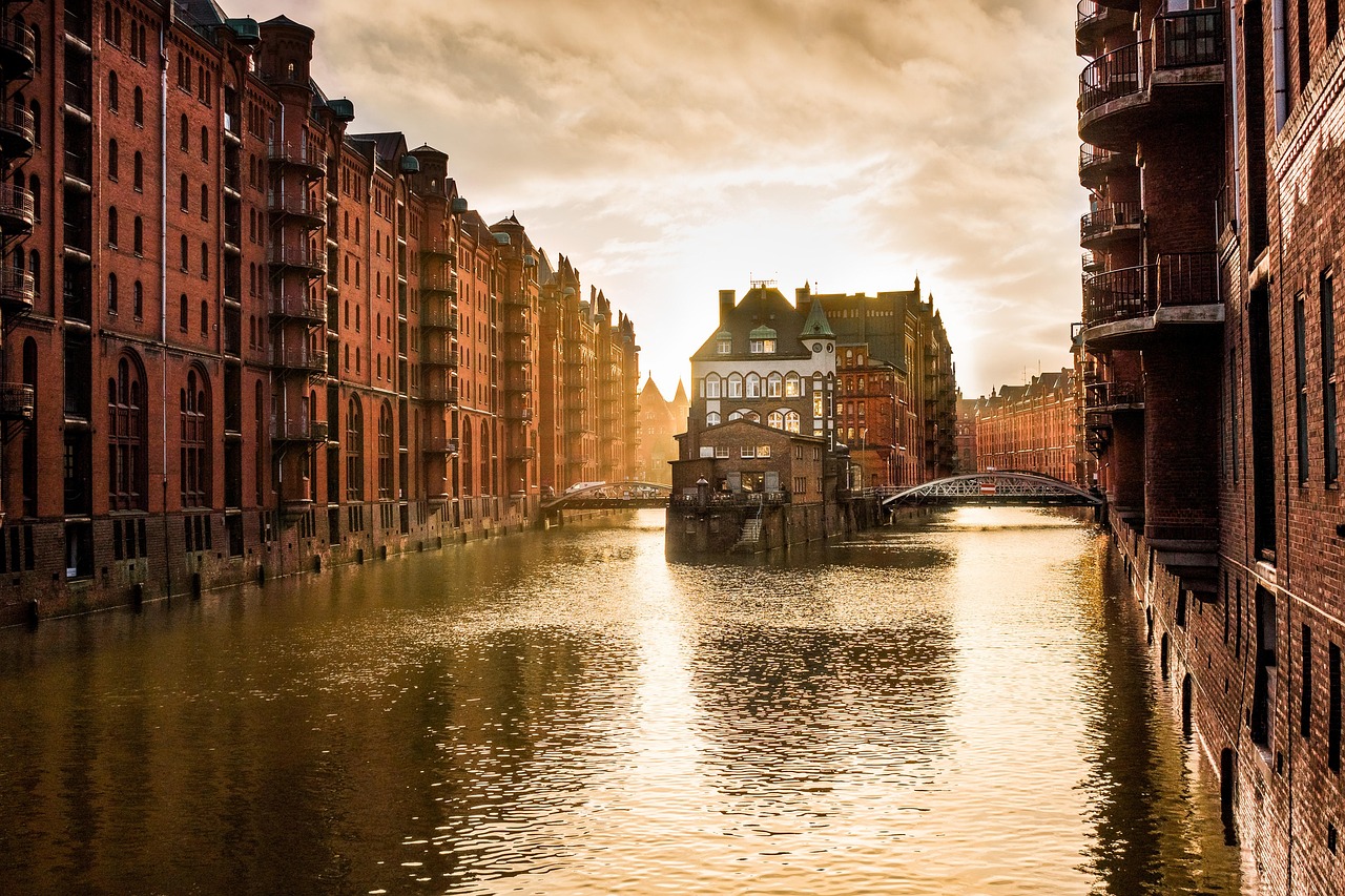 Die Hamburger Speicherstadt mit ihren roten Backsteinbauten und Kanälen im goldenen Licht der Abendsonne.