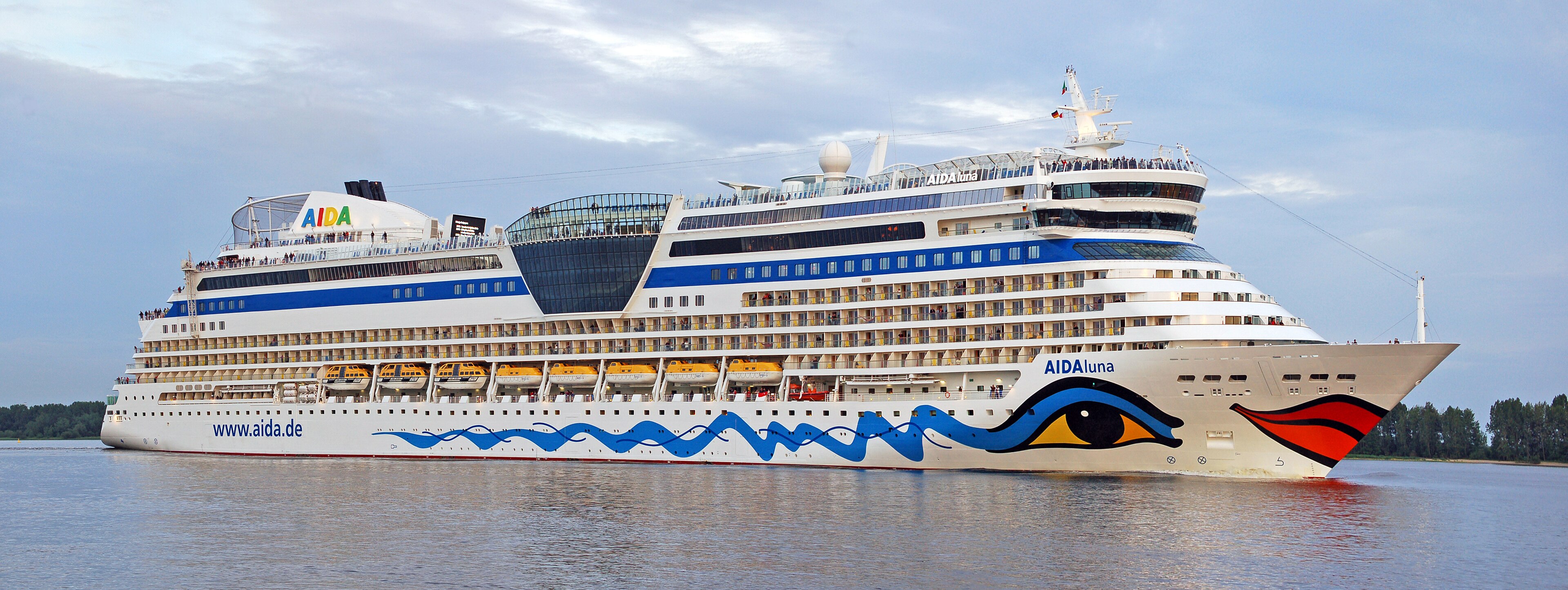 Das Kreuzfahrtschiff AIDA Luna fährt auf dem Wasser, mit vielen Fenstern und Rettungsbooten an der Seite.