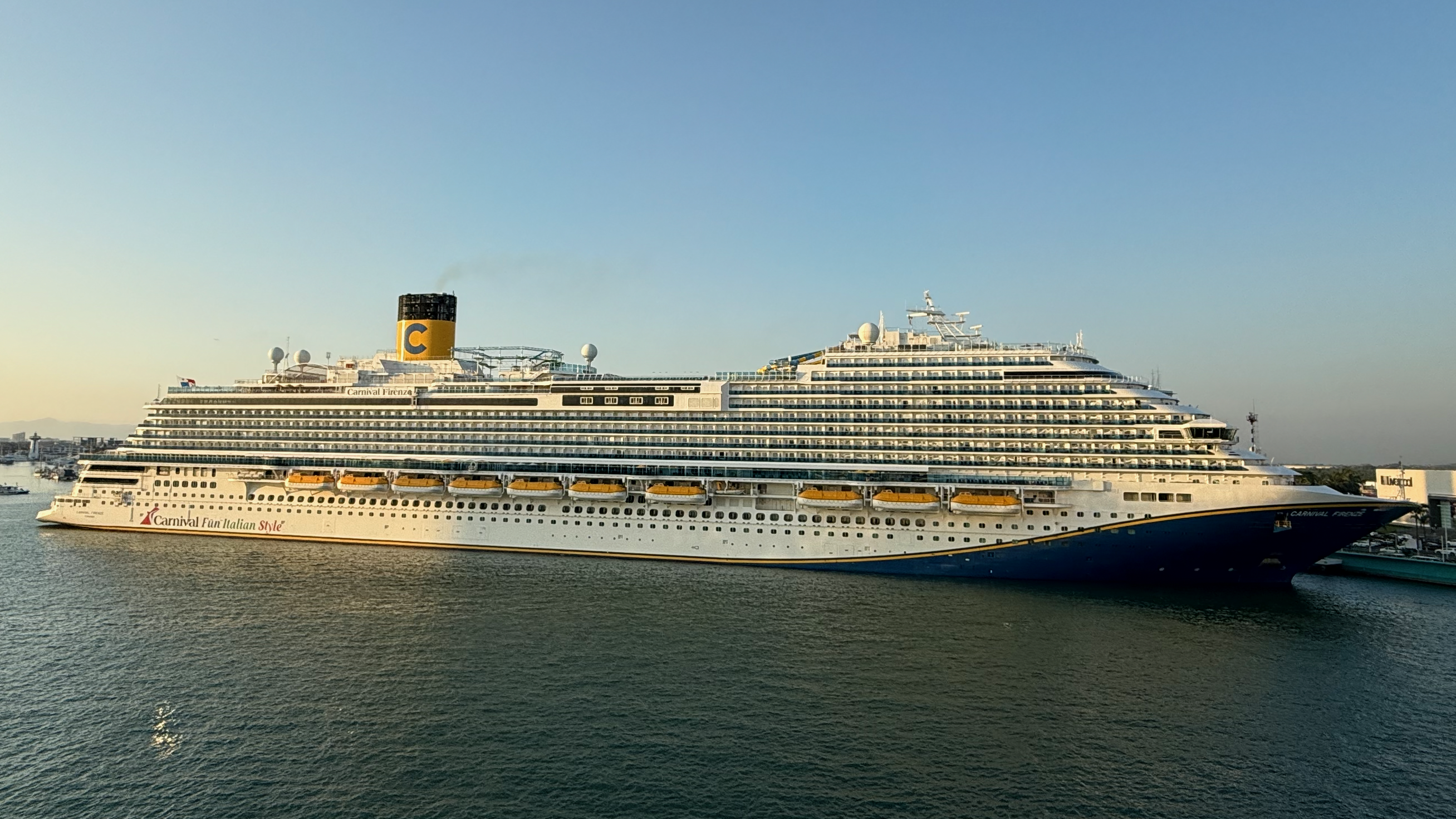 Ein großes Kreuzfahrtschiff namens Carnival Firenze liegt im Hafen vor Anker.