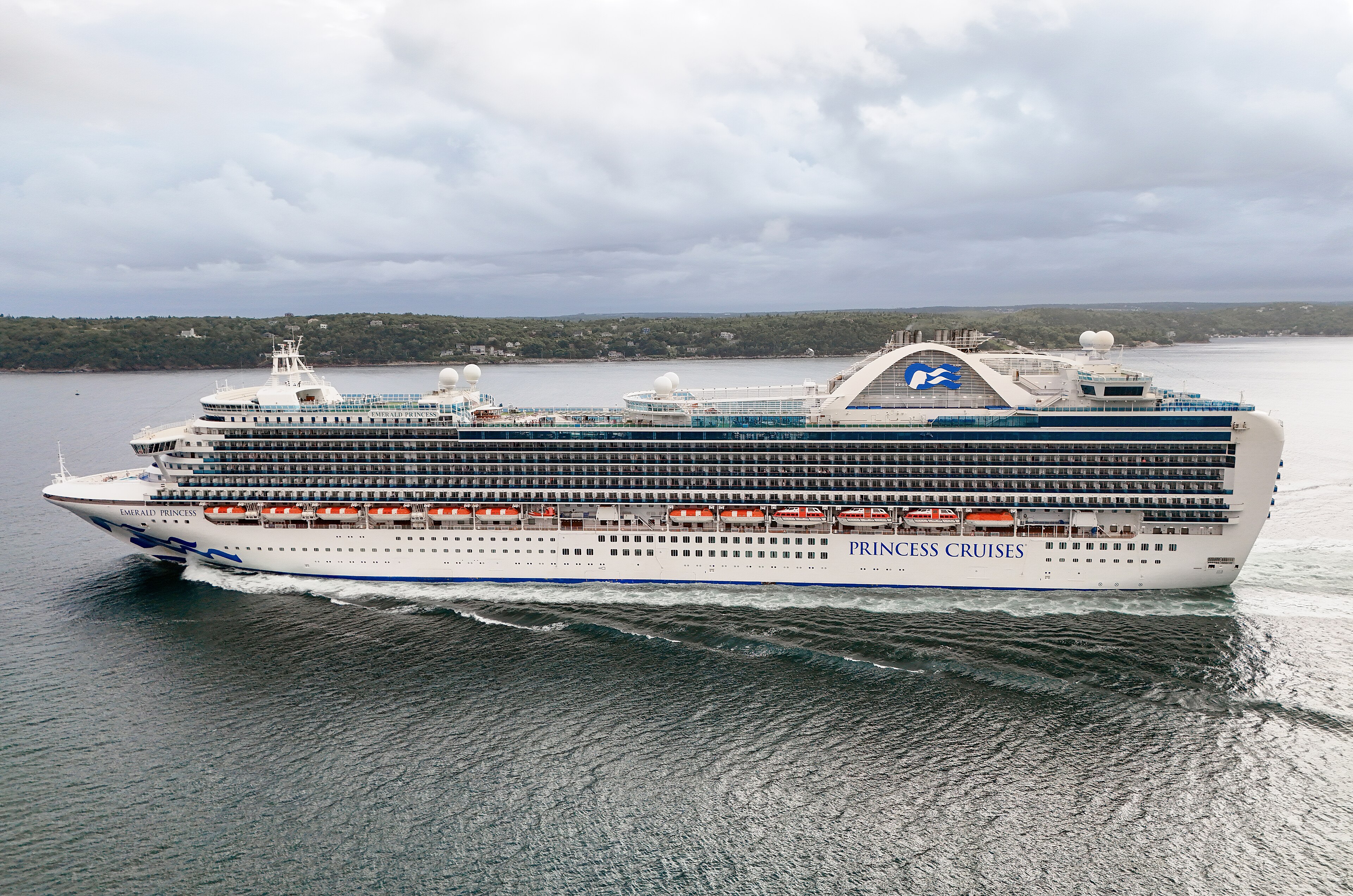 Ein großes weißes Kreuzfahrtschiff der Princess Cruises mit dem Namen Emerald Princess fährt auf dem Meer.