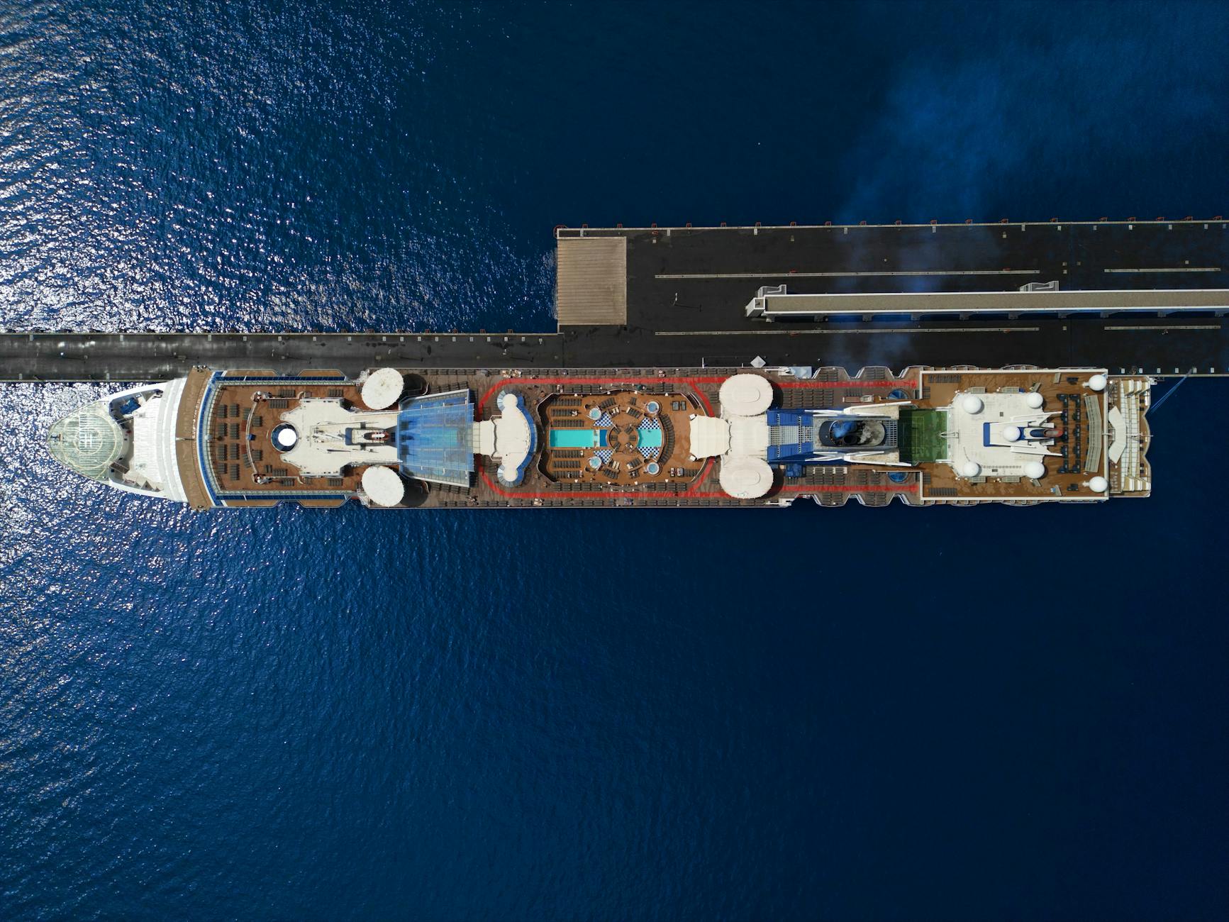 P&O Cruises Kreuzfahrtschiff - Top view of a luxury cruise ship with pool docked at a pier in the ocean.