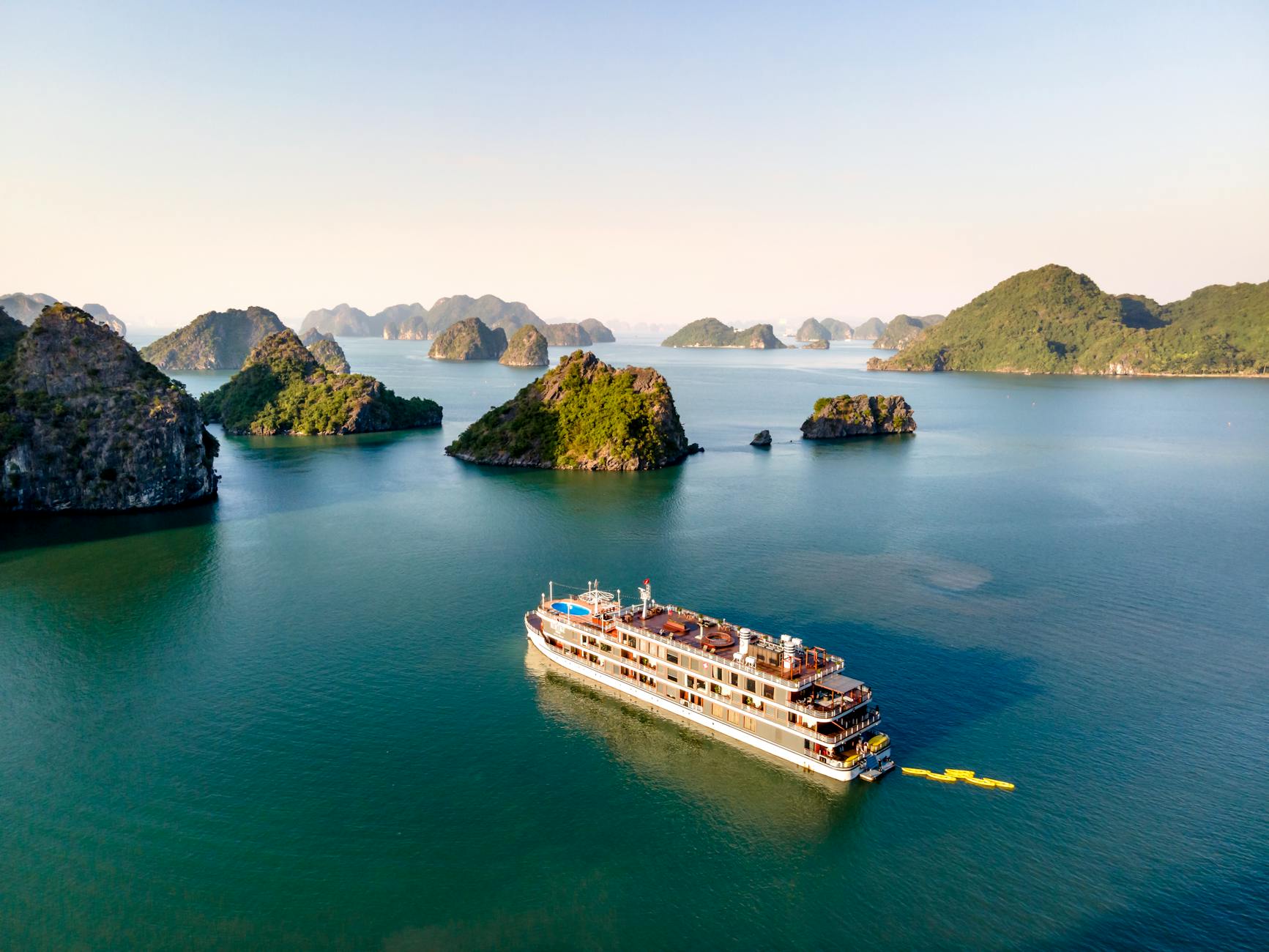 Scenic Luxury Cruises & Tours Kreuzfahrtschiff - Aerial view of a cruise ship navigating through Halong Bay, featuring scenic lim
