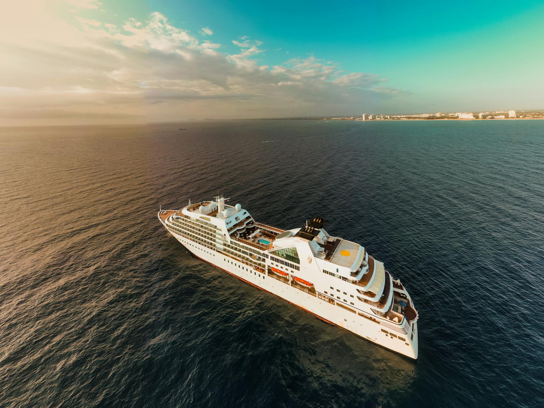 Seabourn Kreuzfahrtschiff - Aerial view of modern white cruise ship sailing on rippling sea water against cl