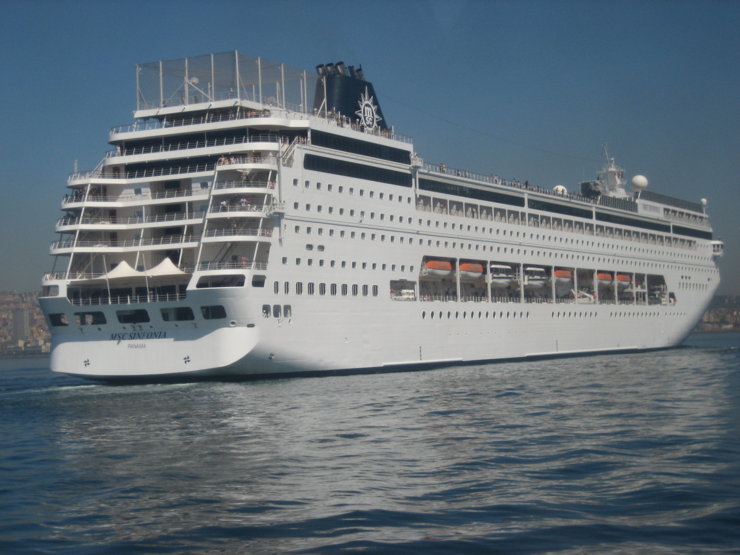 Ein großes weißes Kreuzfahrtschiff mit dem Namen MSC Sinfonia und der Flagge von Panama fährt auf dem Meer.