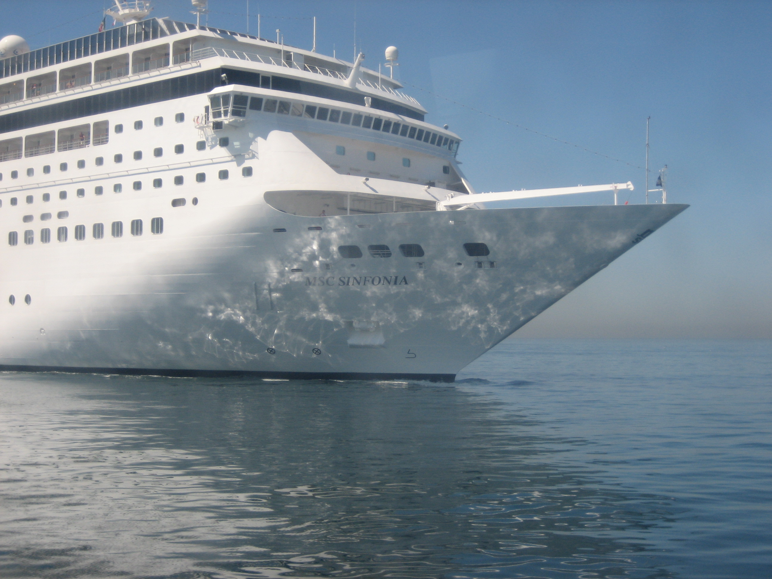 Ein großes weißes Kreuzfahrtschiff namens MSC Sinfonia fährt auf dem Meer.