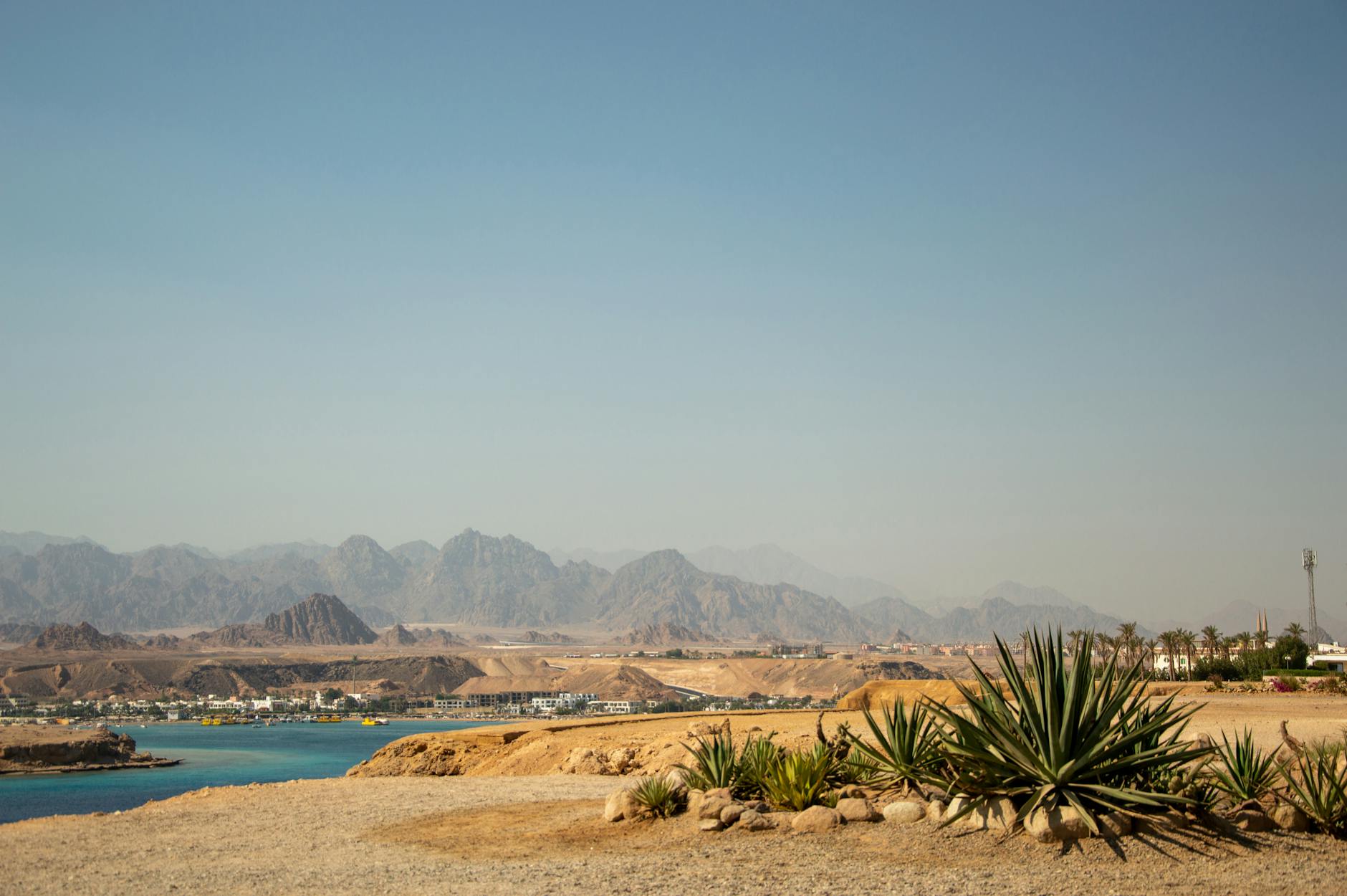 Ägypten - Stunning desert landscape with distant mountains and calm waters under a clear s