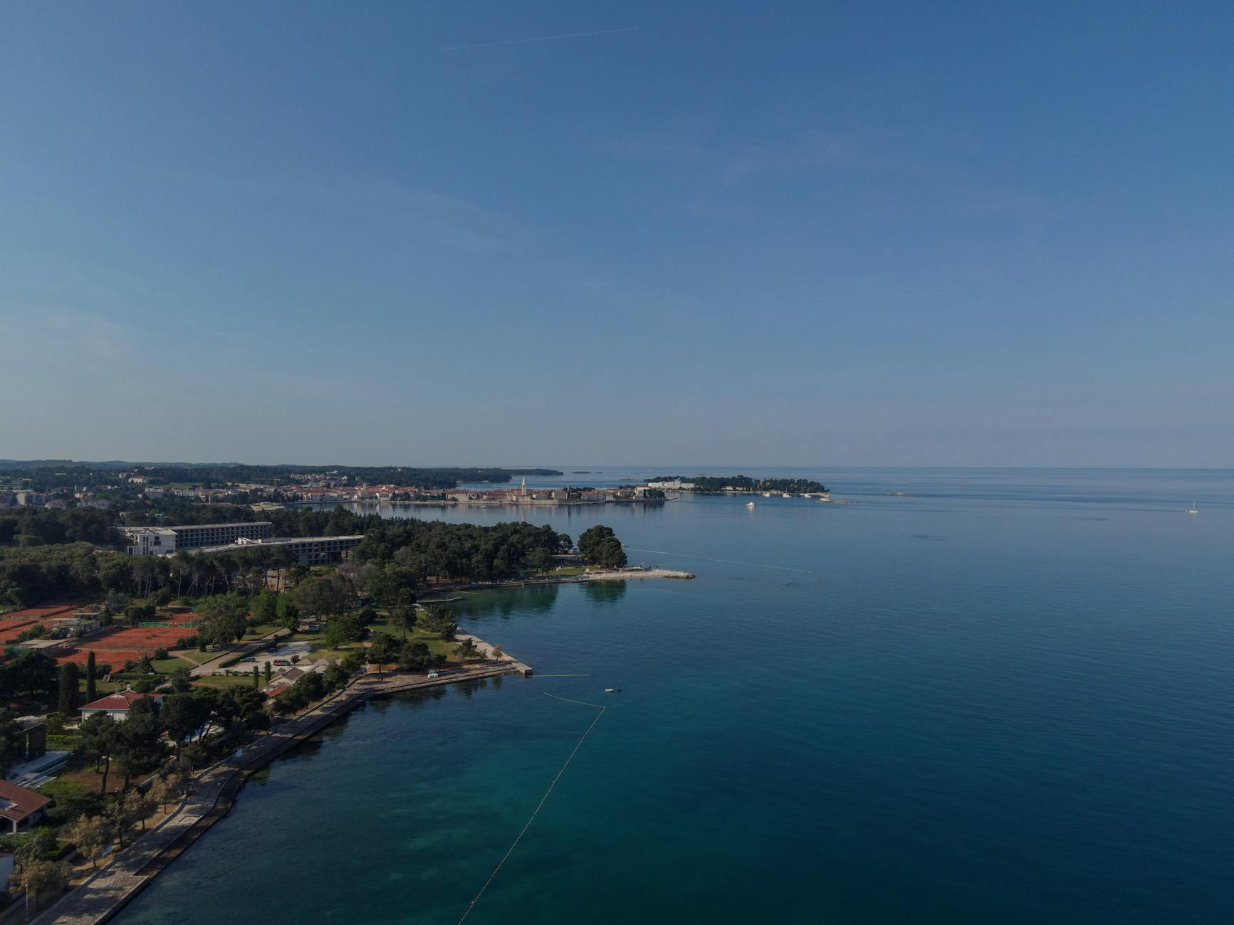 Istrien, Kroatien - Luftaufnahme einer Kuestenstadt am Meer mit Hotelanlagen und Tennisplaetzen.