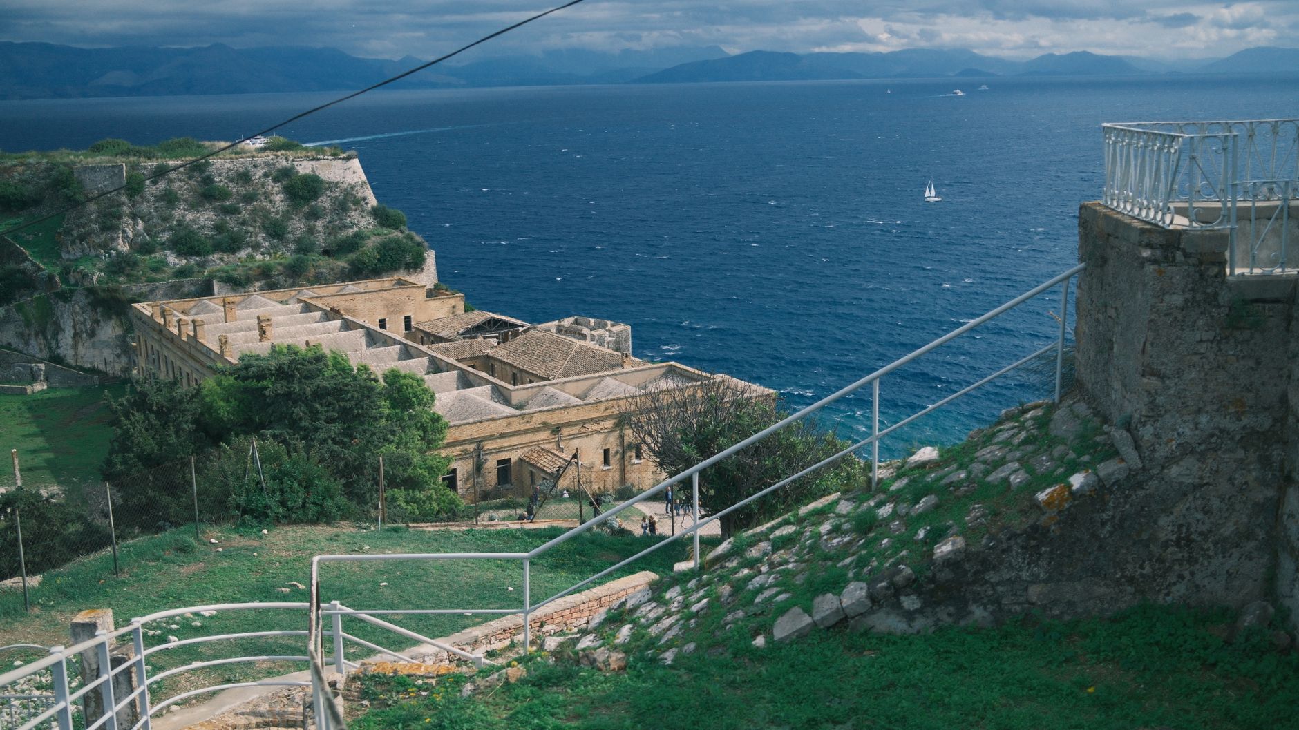 Korfu - View of a historic fortress overlooking a blue sea with distant mountains.
