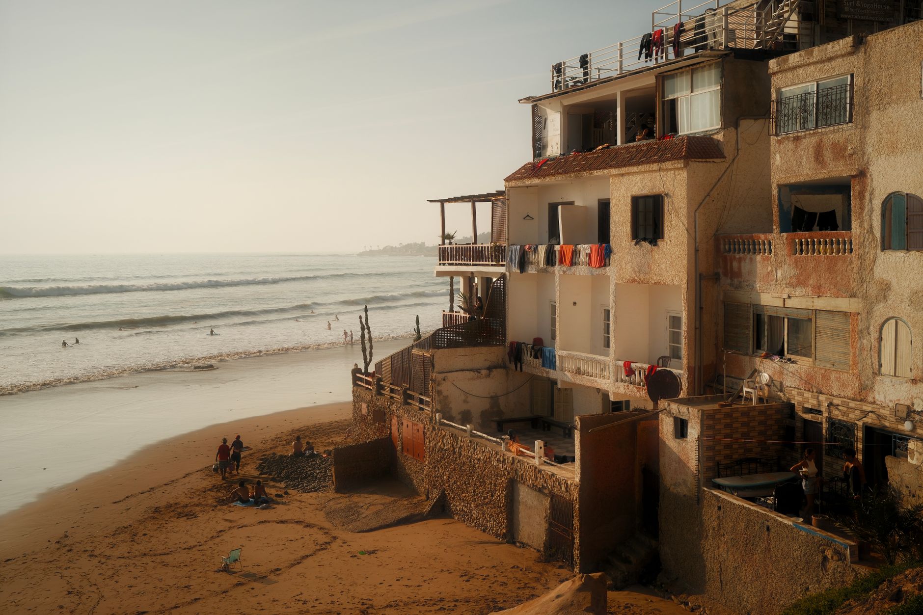 Marokko - Charming Moroccan coastal scene with traditional architecture and beachgoers.