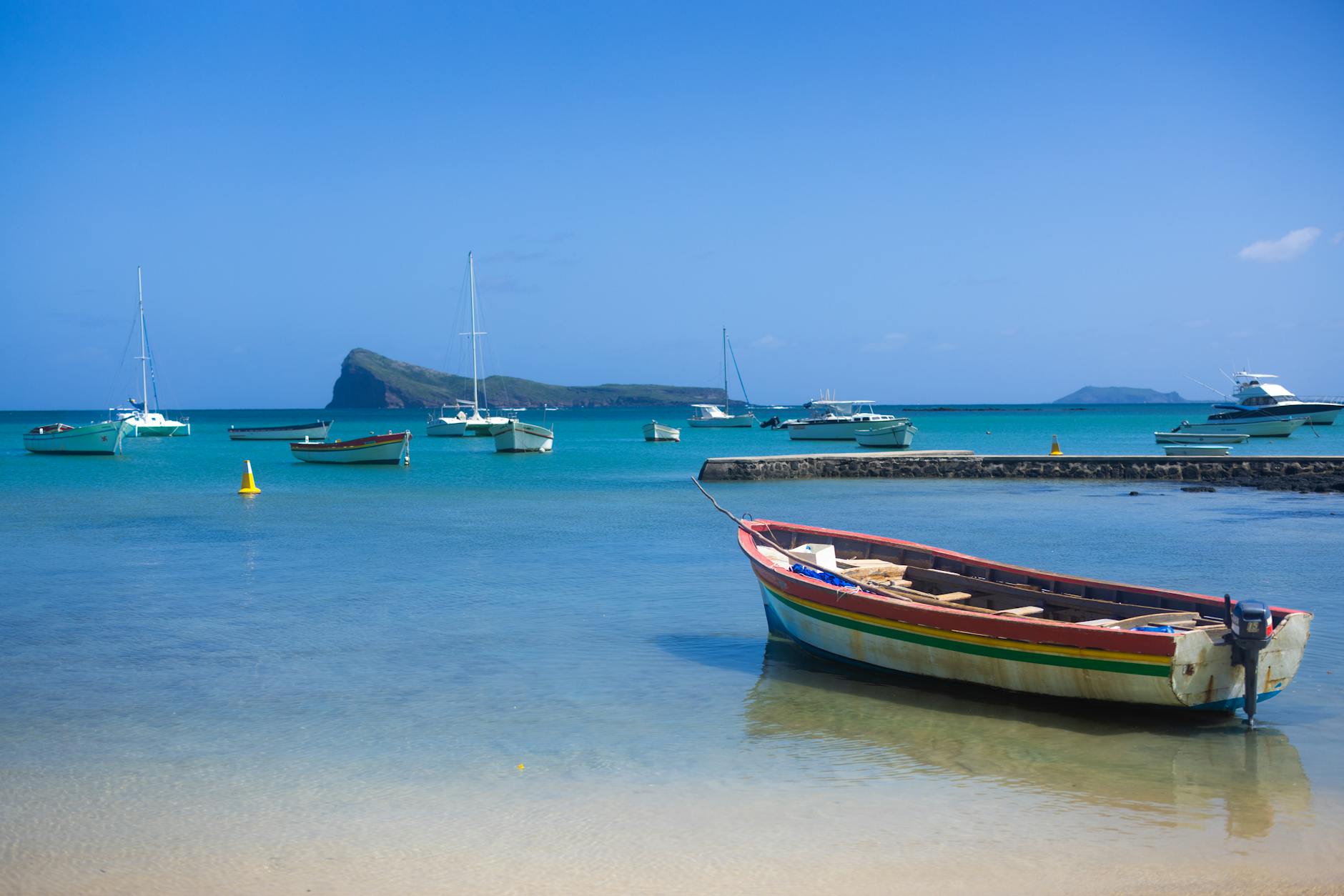 Mauritius - Colorful boats docked in pristine blue ocean with clear skies and distant island