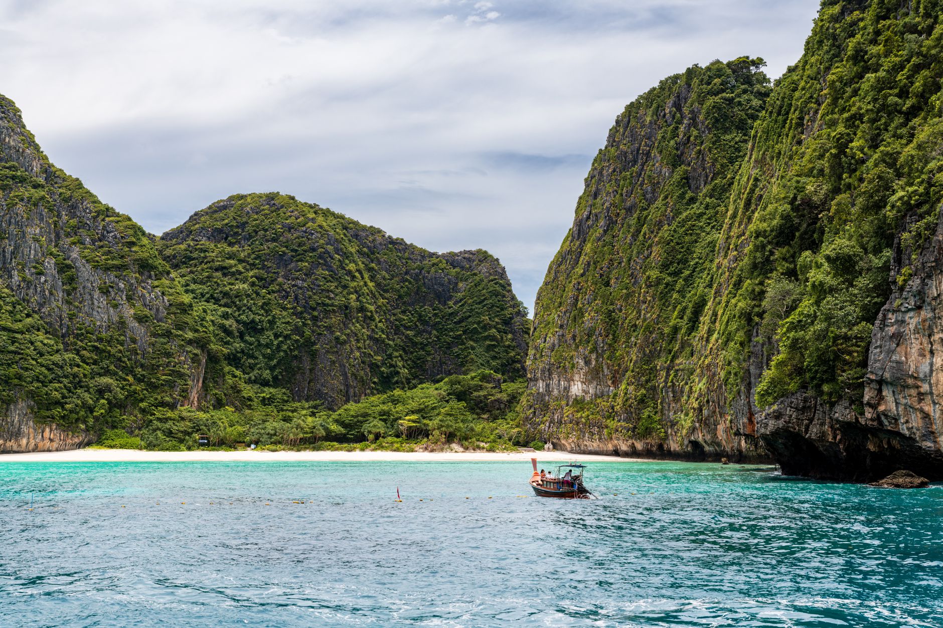 Phuket, Thailand - Idyllic view of a traditional boat against limestone cliffs and turquoise waters