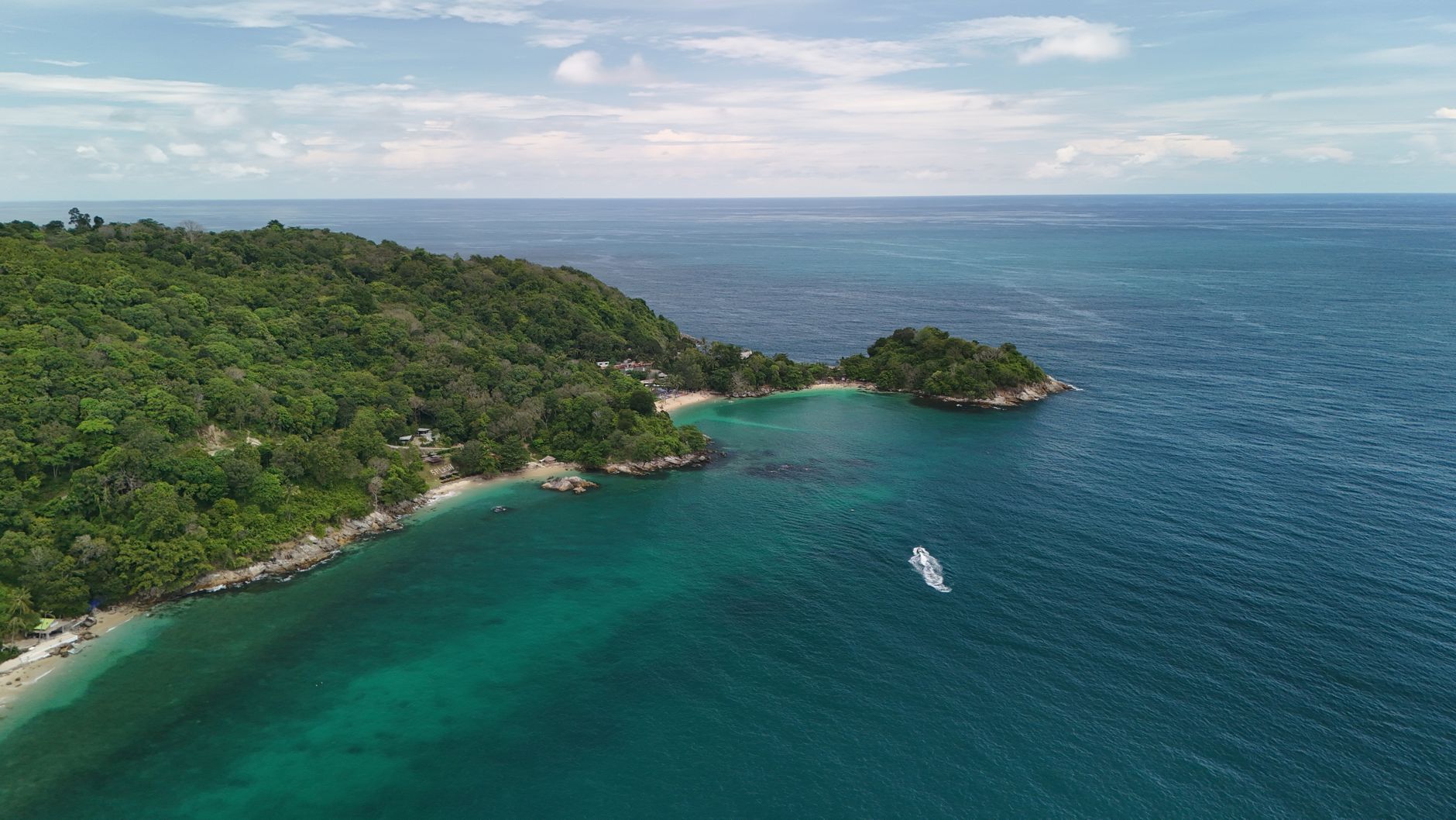 Phuket, Thailand - A stunning aerial view of the tropical coastline with lush forests and azure wat