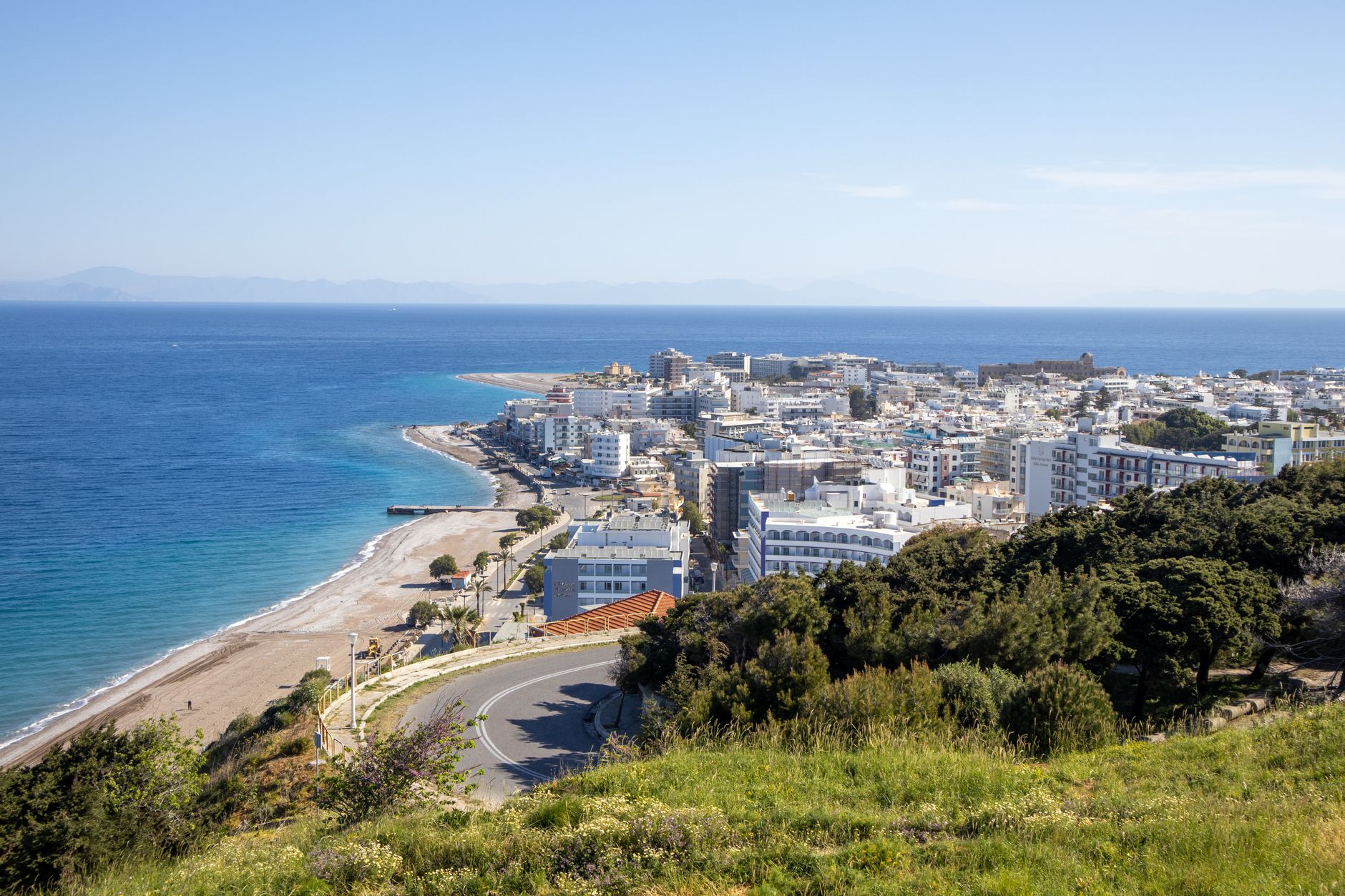 Rhodos - Aerial view of a coastal city with beaches, green hills, and a vast blue sea und