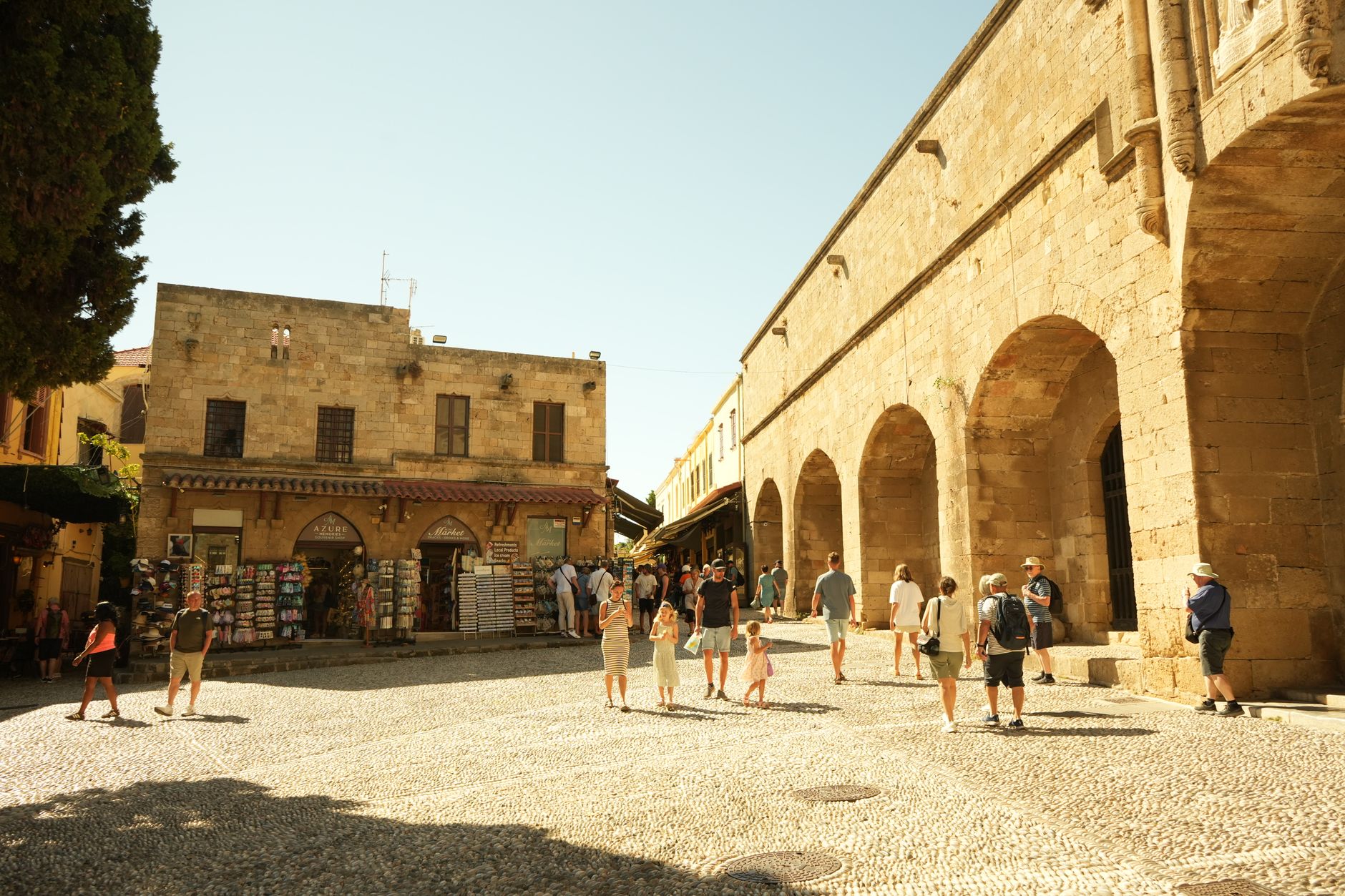 Rhodos, Griechenland - Tourists enjoying a sunny day in the historic old town square surrounded by anci