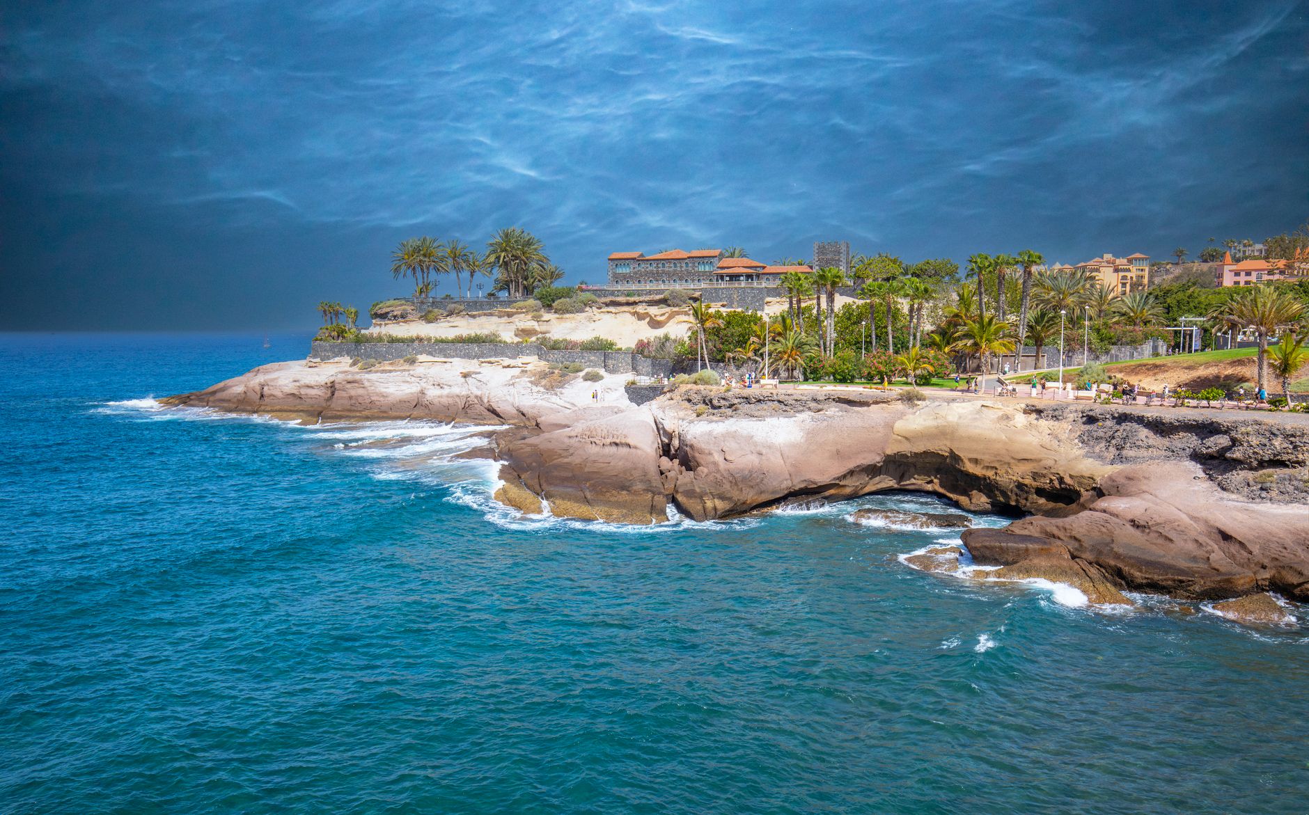 Teneriffa - Breathtaking coastal view of Tenerife with palm trees and rugged cliffs under a 